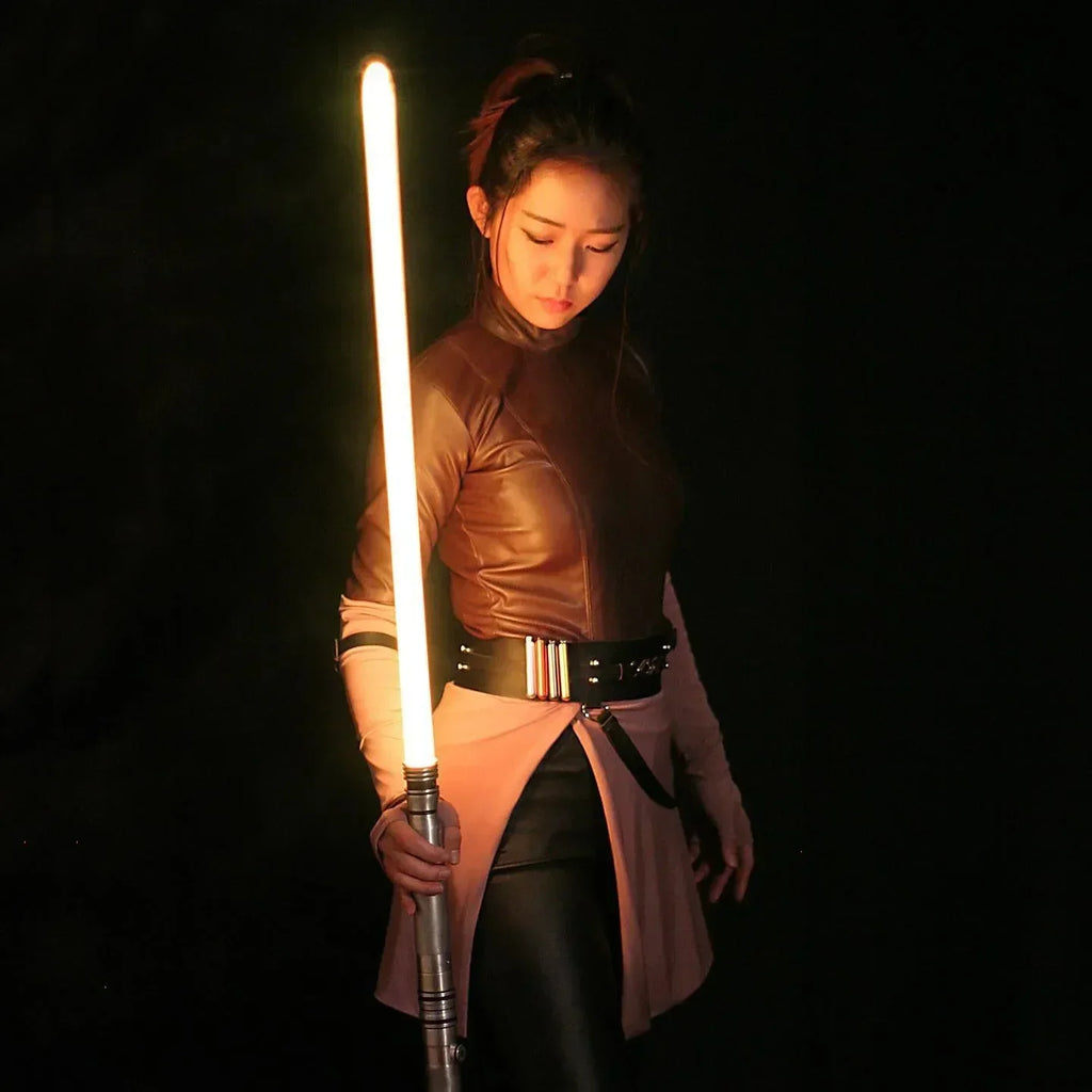 Female Jedi cosplayer holding a Star Wars-inspired custom neopixel lightsaber saberstaff yellow blades