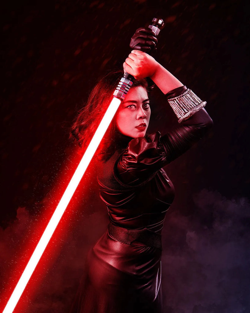 Female Sith cosplayer wielding a Star Wars-inspired custom neopixel lightsaber with a red blade over the shoulder
