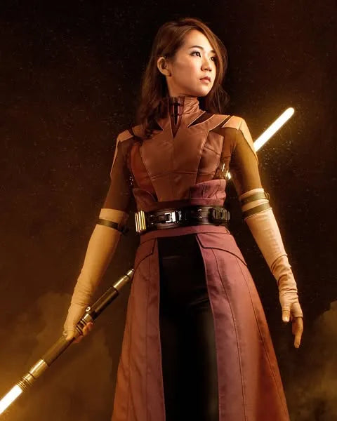 Bastila Shan-inspired cosplayer holding an amber neopixel saberstaff, representing a Jedi Sentinel bringing injustice to light