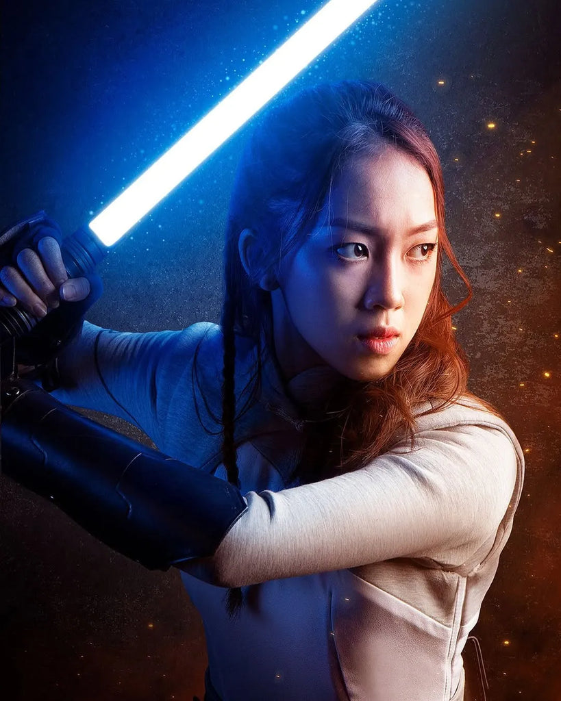 Female Obi-Wan Kenobi-inspired cosplayer holding a Rahm Kota-inspired custom neopixel lightsaber with a blue blade