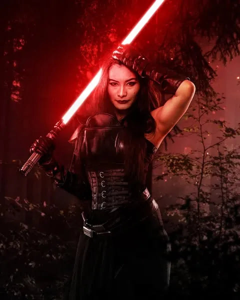 Sith-inspired cosplayer with a dismissive expression, holds a Sith-inspired custom neopixel lightsaber with a glowing crimson red blade