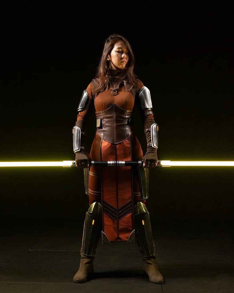 Bastila Shan-inspired cosplayer holding saberstaff Arclyte, a Clone Wars-inspired custom neopixel lightsabers with yellow blades