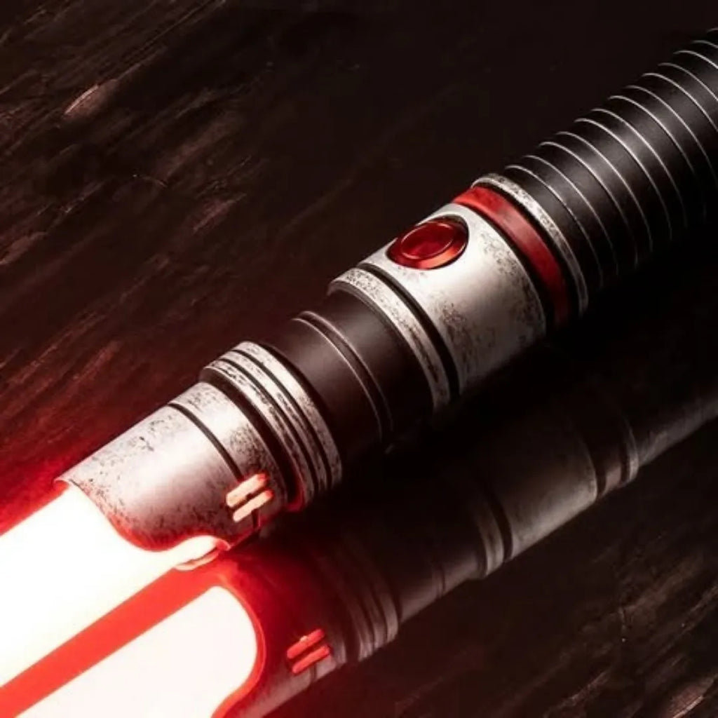 Close-up of a Rahm Kota-inspired custom neopixel lightsaber features weathered finish with red accents and crimson blade