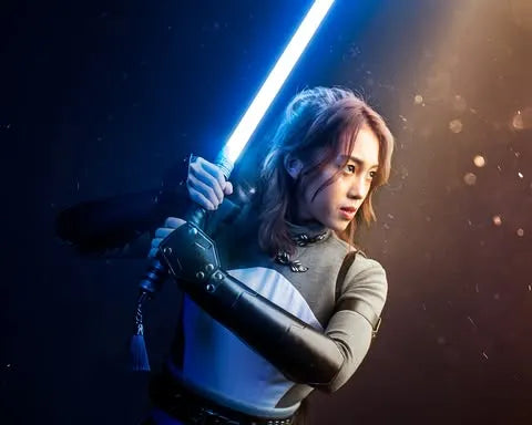 Female Jedi-inspired cosplayer holding a Rahm Kota custom neopixel lightsaber with a tassel, inspired by resilience of the Jedi Order