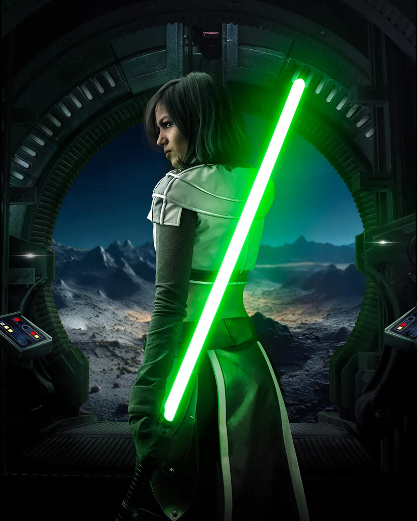 Female Jedi-inspired cosplayer standing in a sci-fi doorway holding a Rahm Kota-inspired custom neopixel lightsaber with green blade