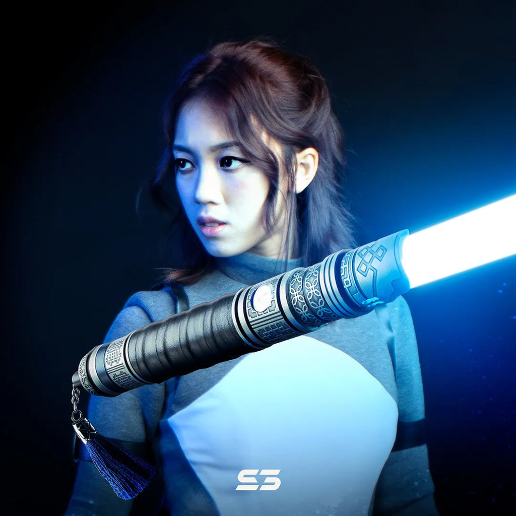 Female Jedi-inspired cosplayer with Rahm Kota-inspired custom neopixel lightsaber featuring silver finish, leather wrap, blue blade