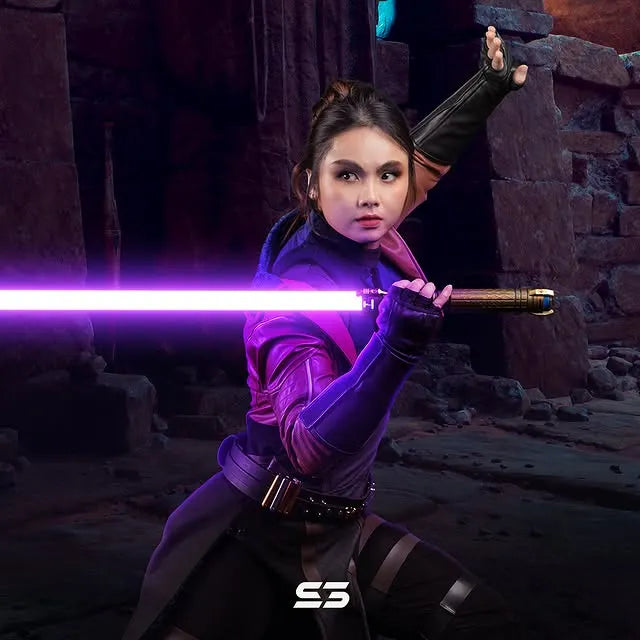 Female Jedi-inspired cosplayer holding a Sith-inspired custom neopixel purple lightsaber features fiery rising wings and dagger motifs